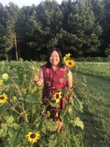 Melissa Lam-McCarthy standing in a field of sunflowers